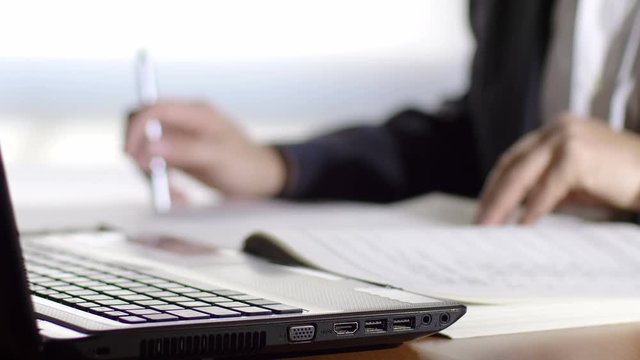 businessman at work in his office checking some list on paper sheets