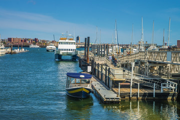 Pier of Boston Wharf and sail boats in Charles River