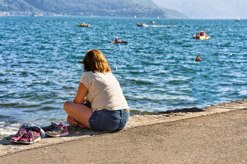 Woman sitting on bench in Ascona resort at Ticino Switzerland