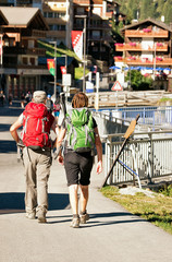 Backpackers at the street of resort city Zermatt
