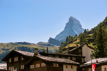 Chalets of resort city Zermatt with Matterhorn with flag