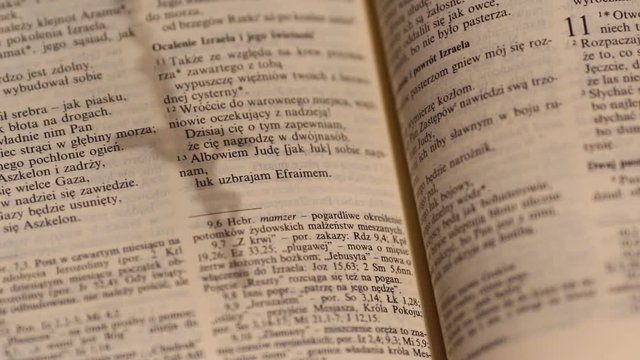 rosary, cross shadow over an open bible