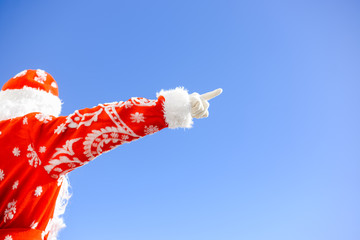 Santa Claus pointing finger up light blue background. Back view