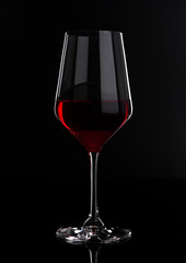 Glass of red wine with reflection on black
