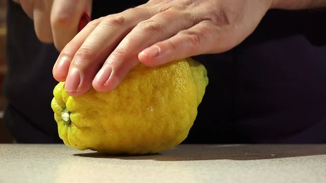 man cutting yellow lemon