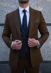 Male model in a brown suit posing up close