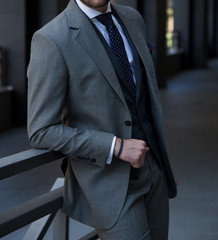 Male model in a grey suit posing up close