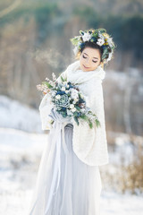 Cute bride with a bouquet. Winter wedding bouquet.