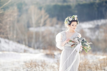 Beautiful bride admiring wedding bouquet. Winter wedding. Winter wedding bouquet.