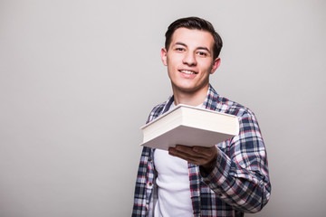 Portrait of a smiling man in suit giving book to camera over white background