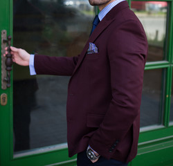 Male model in a suit opening a door
