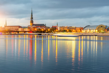 Night view on the illuminated riverside with reflection on the river in Riga, Latvia