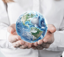 Close up of woman in white blouse holding planet
