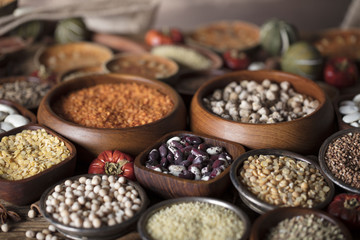 Healthy food and diet theme. Lentils, peas, beans, protein food in bowls, on a wooden table.