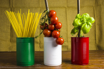 spghetti, pomodori e basilico in lattine colorate con la bandiera italiana