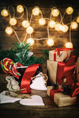 Christmas Gifts with Boxes, Coniferous, Basket, candy cane Cones on Wooden Background. Vintage...
