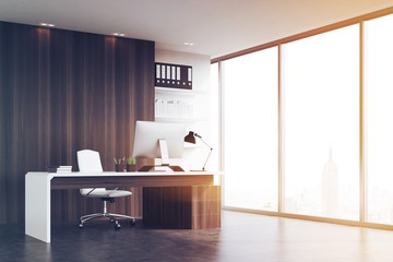Office of company head with dark wood walls, toned