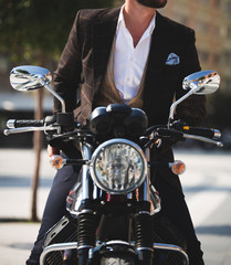 Male model in a suit posing on a motorcycle