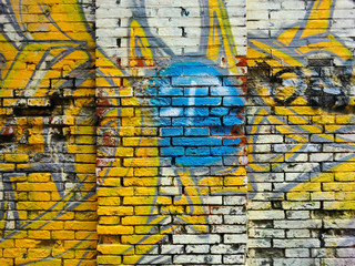 Brick building exterior wall texture with spray paint graffiti