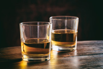 Glasses of whiskey on a wooden table