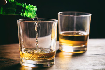 Glasses of whiskey on a wooden table