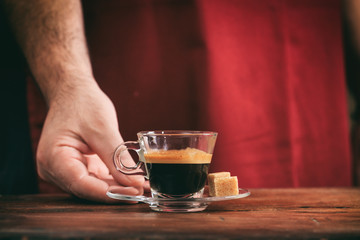 Waiter holding a cup of espresso