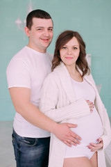 Fototapeta premium Family waiting for baby's birth. A pregnant woman and her husband wearing white clothing