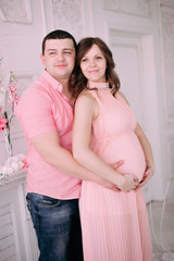 Family waiting for baby's birth. A pregnant woman and her husband wearing white clothing