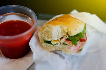 Tasty hamburger and tomato juice as the main prepared for economy class airline passengers with sun coming from the plane window