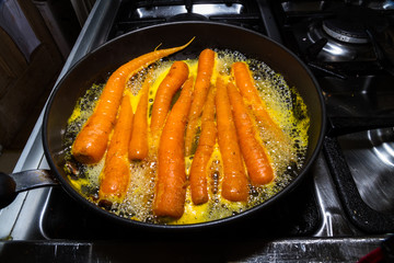 Carrots being glazed in orange juice.