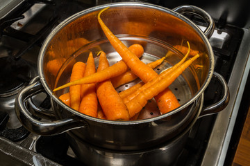Carrots being steamed on cooker.