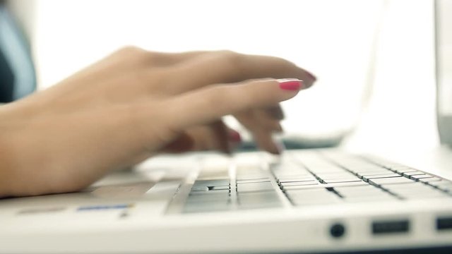 woman's hands typing on the keyboard of a laptop