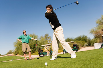 Obraz premium Full length of young Caucasian friends playing golf at golf course