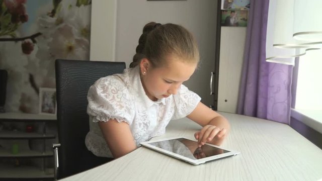 Teenager girl working a digital tablet computer at home