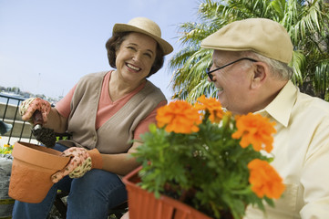 Happy senior woman and man working in the garden