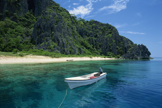 Boat moored off a secluded beach on Coron Island, Palawan, Philippines