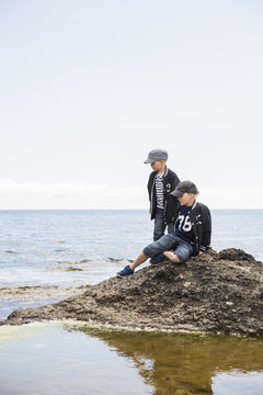 Sweden, Gotland, Boys (6-7, 8-9) on rock in sea