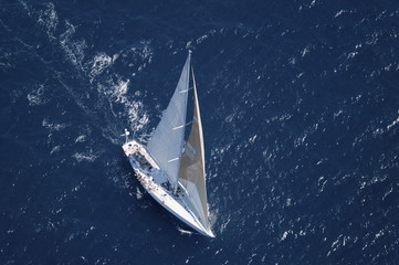 Top view of a sailboat in the peaceful blue ocean