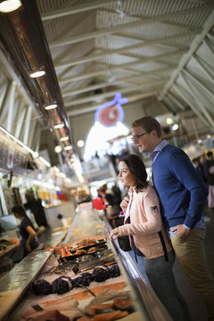 Sweden, Vastergotland, Gothenburg, Young couple buying seafood at market