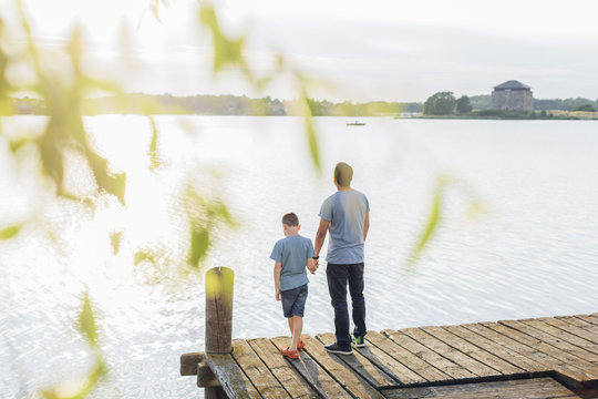 Sweden, Blekinge, Karlskrona, Father and son (8-9) by lake