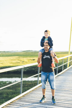 Germany, Schleswig-Holstein, Kreis Nordfriesland, Portrait of father giving son (8-9) piggyback ride