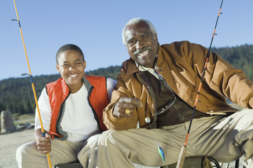 Portrait of happy grandfather and grandson fishing together