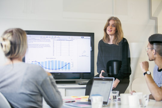 Businesswoman giving presentation to colleagues in office meeting
