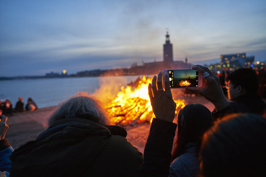 Sweden, Sodermanland, Stockholm, Riddarholmen, Person taking photo of bonfire