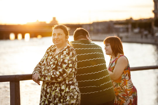 Sweden, Sodermanland, Stockholm, Sodermalm, Slussen, Woman with down syndrome standing by railing on promenade in company of boyfriend and friend