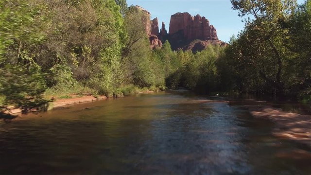 AERIAL: Flying above river towards beautiful Sedona Red Rock Cathedral