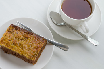 Caramel Peanut-Topped Brownie Cake with A Cup of Tea.