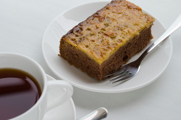 Caramel Peanut-Topped Brownie Cake with A Cup of Tea.