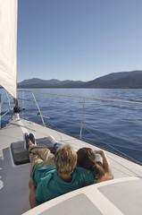 Fototapeta premium Rear view of a couple relaxing on a sailboat