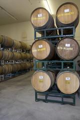 Stack of wine barrels on a stand stored in an old cellar of the winery